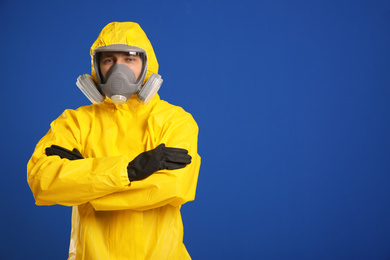 Man wearing chemical protective suit on blue background, space for text. Virus research