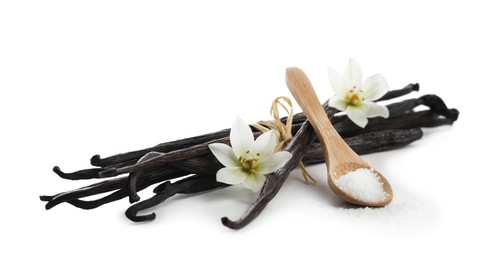 Photo of Vanilla pods, spoon with sugar and flowers isolated on white