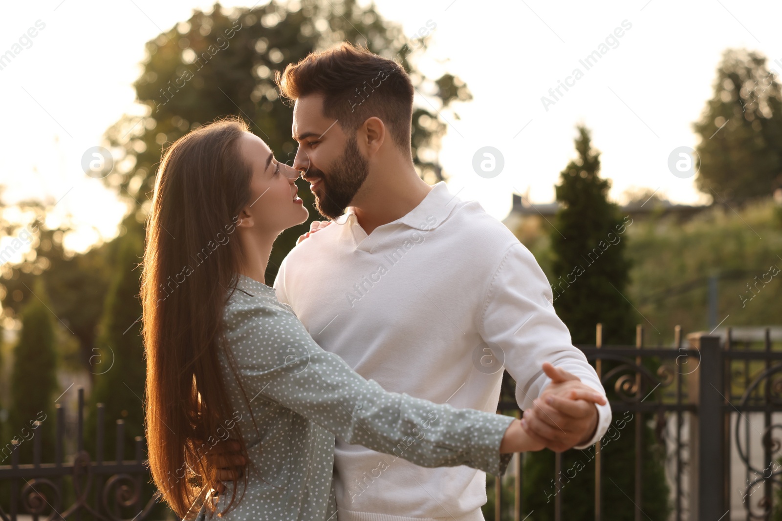 Photo of Lovely couple dancing together outdoors at sunset