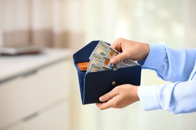 Photo of Woman with American money in wallet indoors, closeup