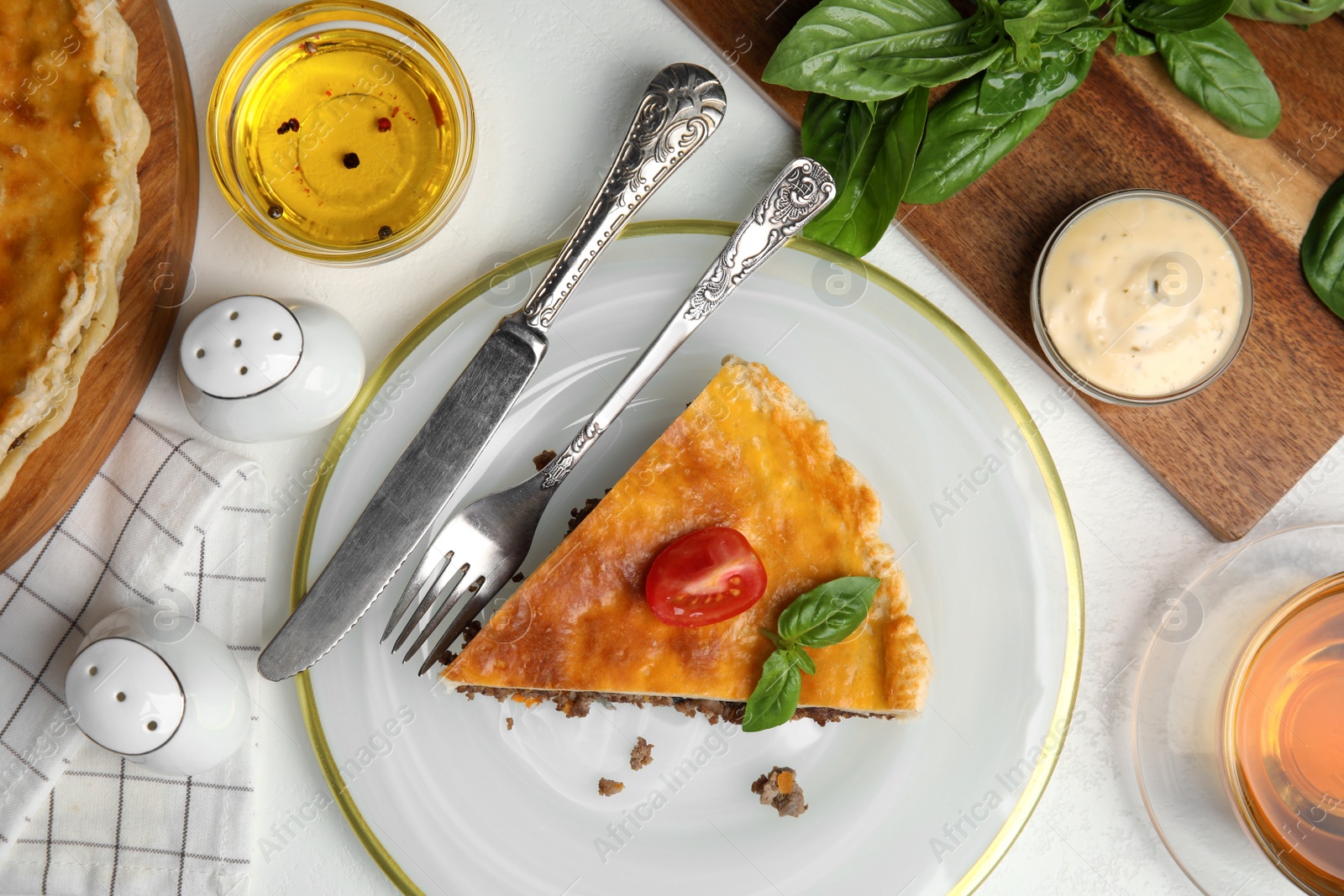 Photo of Piece of delicious pie with minced meat, tomato and sauce served on white table, flat lay