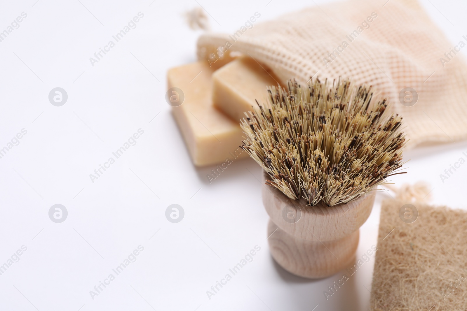 Photo of Cleaning brush, sponge and soap bars on white background, closeup. Space for text