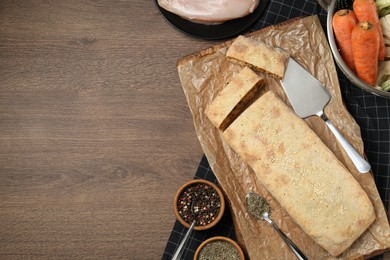 Delicious strudel with chicken and vegetables served on wooden table, flat lay. Space for text