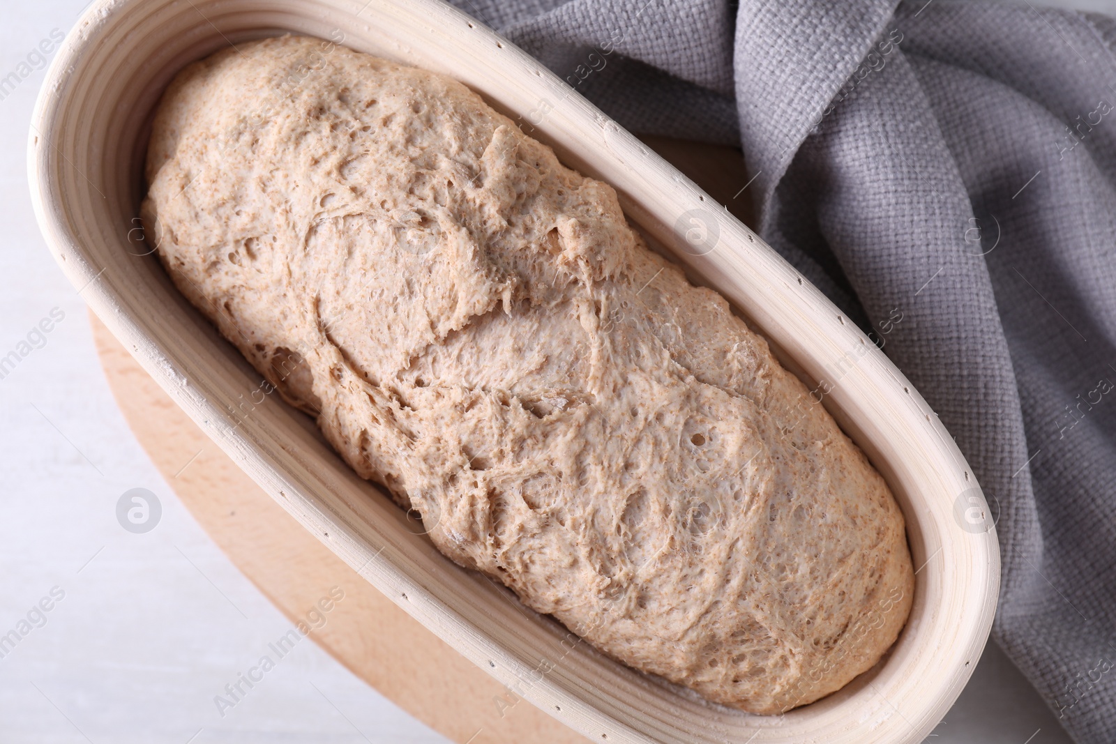 Photo of Fresh sourdough in proofing basket on light table, top view