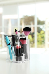 Organizer with cosmetic products for makeup on table indoors