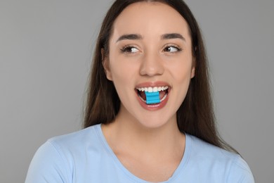 Photo of Woman with bubble gum on grey background