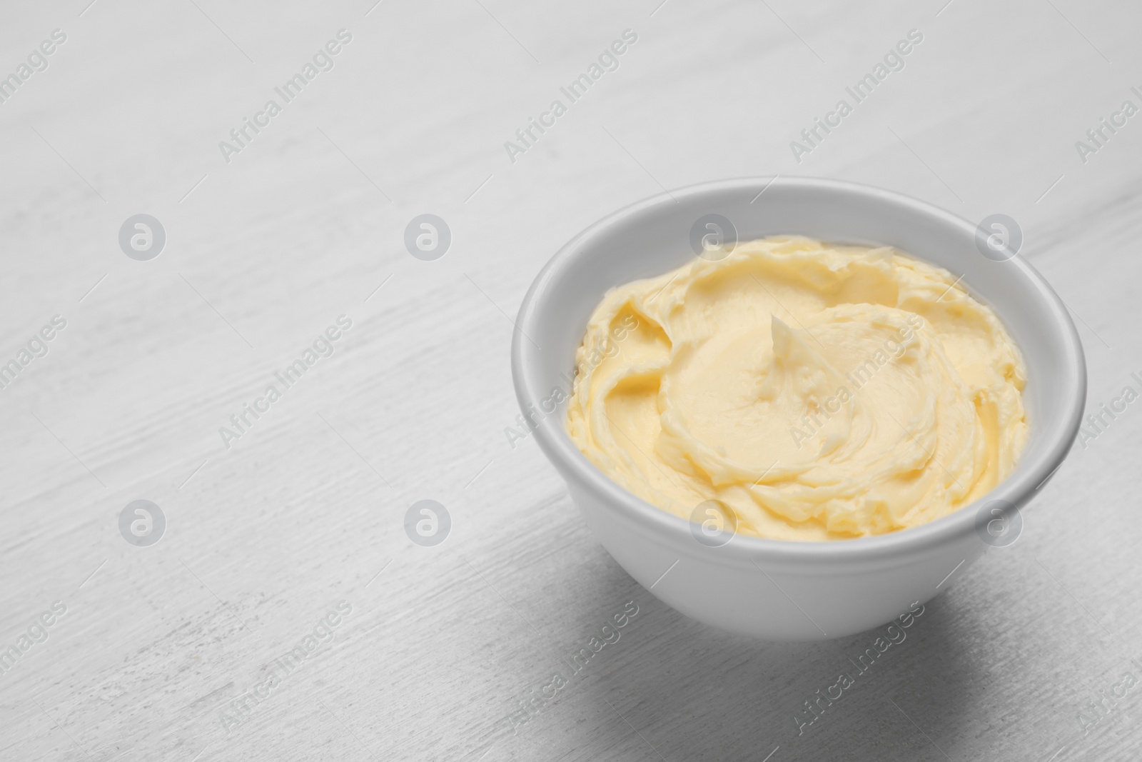 Photo of Bowl with tasty fresh butter on table