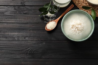 Photo of Flat lay composition with soaked rice on black wooden table. Space for text