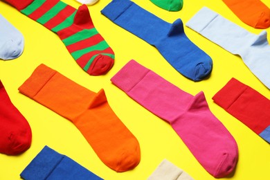 Photo of Composition of different colorful socks on yellow background