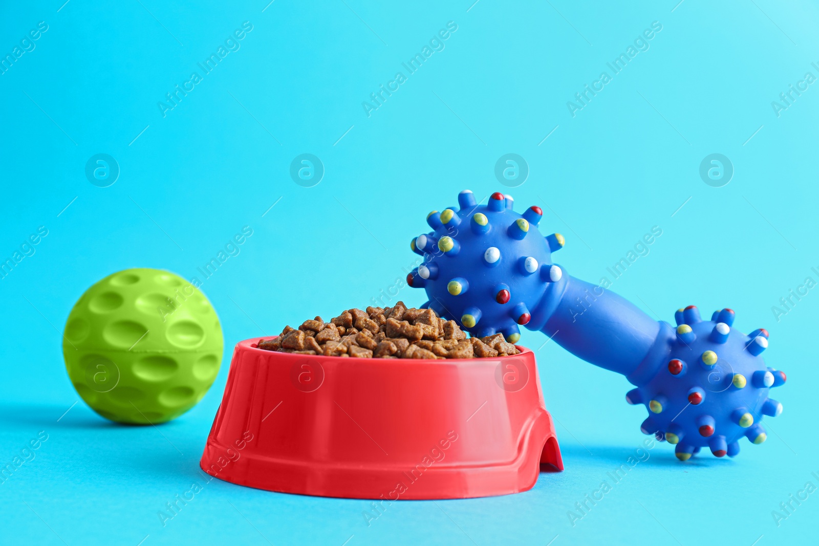 Photo of Pet toys and feeding bowl on light blue background