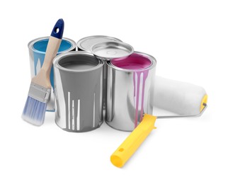 Photo of Cans of colorful paints, brush and roller isolated on white