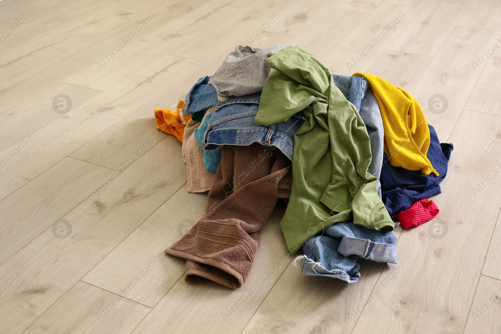 Photo of Pile of dirty laundry on wooden floor indoors