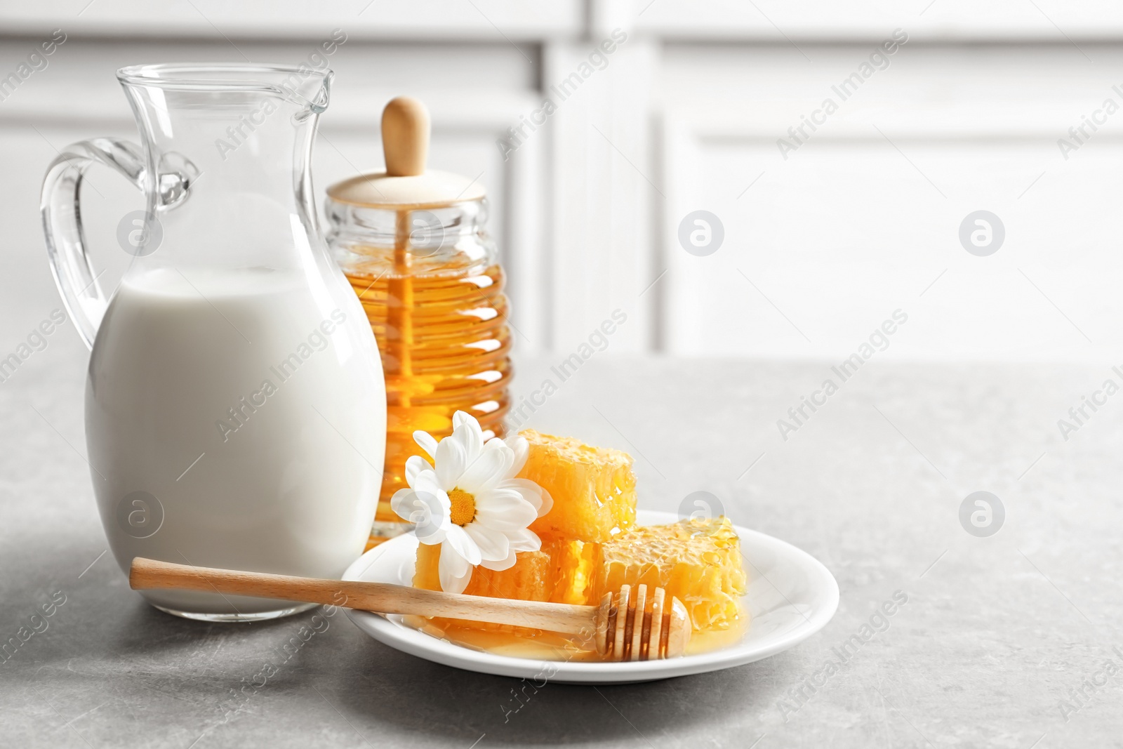 Photo of Beautiful composition with milk and honey on table