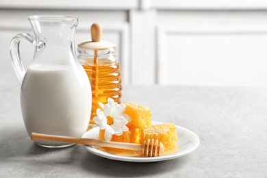 Photo of Beautiful composition with milk and honey on table