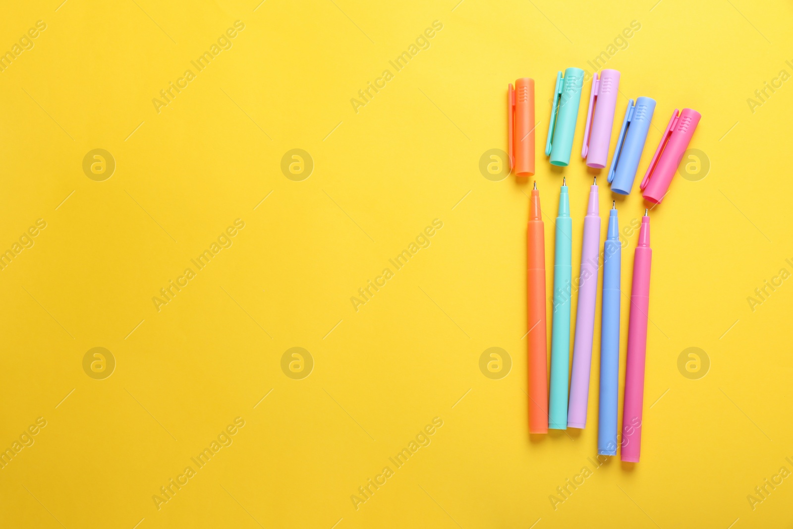 Photo of Many colorful markers on yellow background, flat lay. Space for text