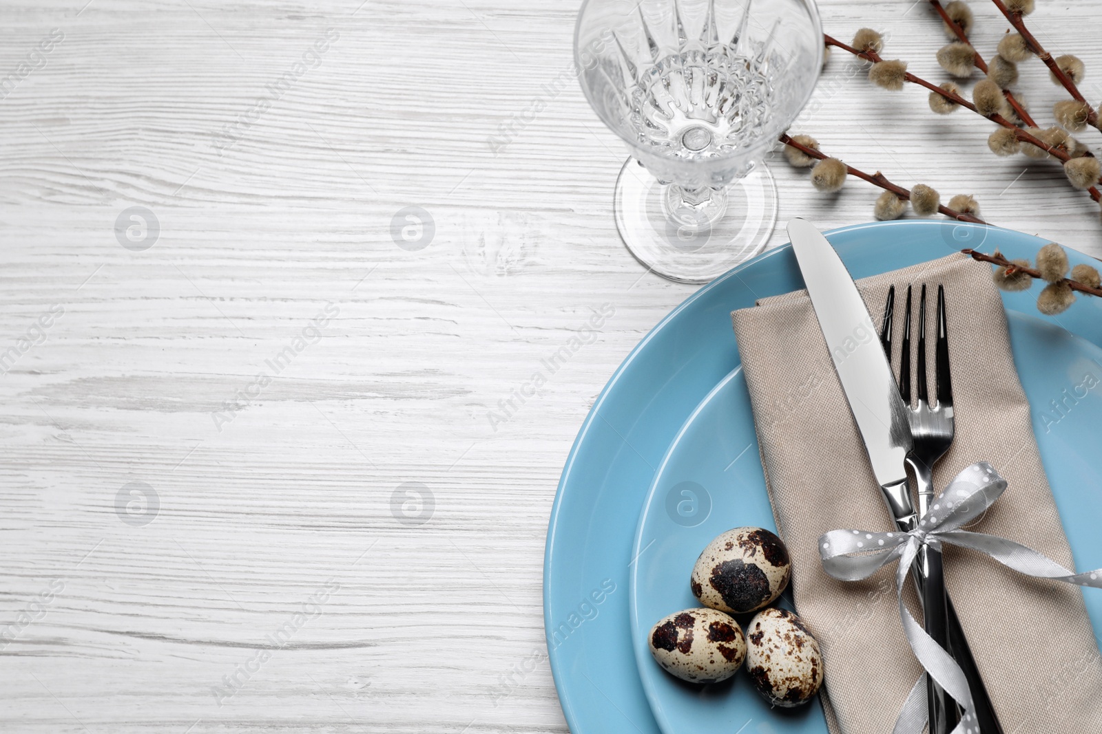 Photo of Festive Easter table setting with eggs on white wooden background, flat lay. Space for text