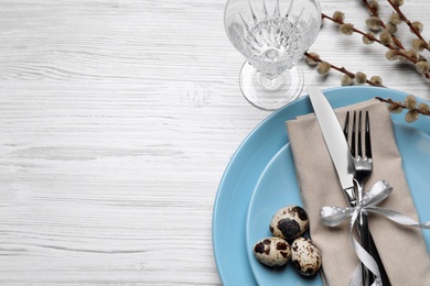 Photo of Festive Easter table setting with eggs on white wooden background, flat lay. Space for text