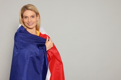Photo of Woman with flag of France on light grey background, space for text