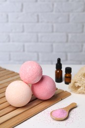 Photo of Beautiful aromatic bath bombs and sea salt on white table, space for text