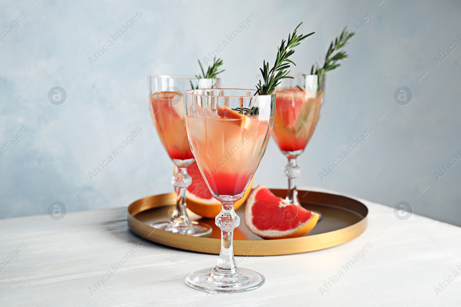 Photo of Glasses of tasty grapefruit cocktails on table