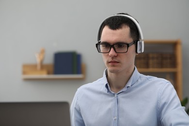 E-learning. Young man using laptop during online lesson indoors