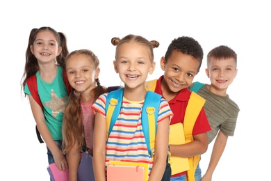 Group of little children with backpacks and school supplies on white background