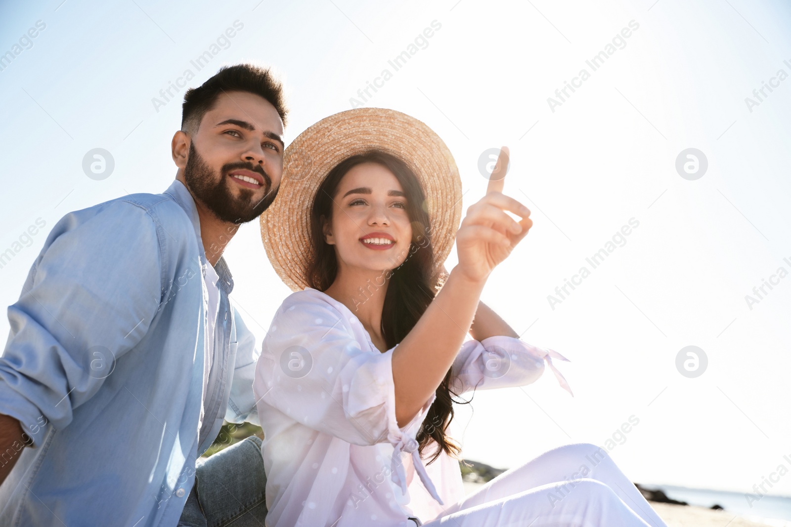 Photo of Happy young couple on beach near sea. Honeymoon trip