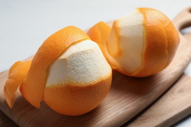 Photo of Peeled fresh oranges with zest preparing for drying on white table, closeup