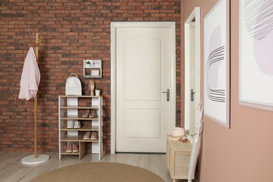 Modern hallway interior with white door and wooden furniture