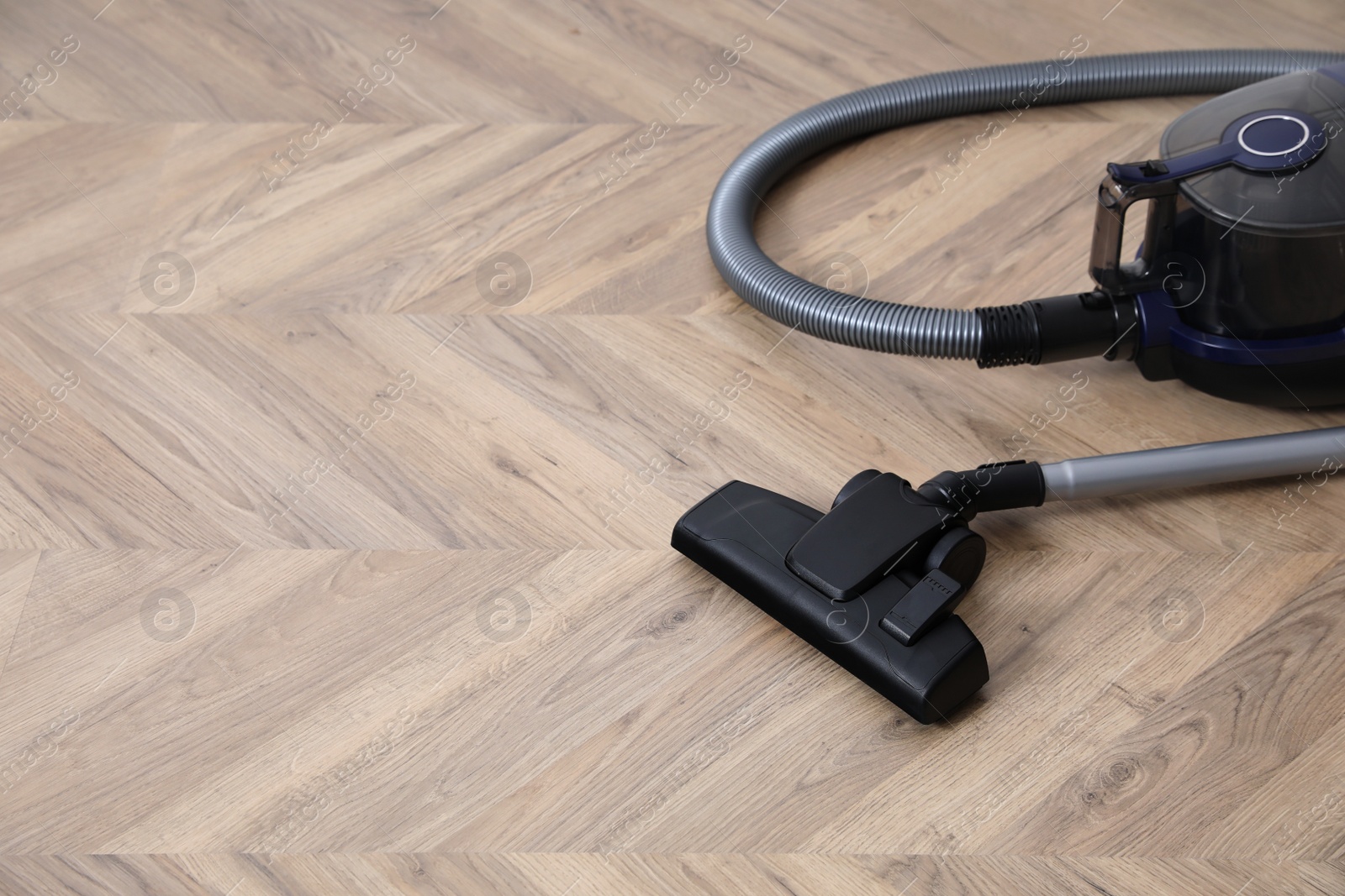 Photo of Modern vacuum cleaner on floor. Space for text