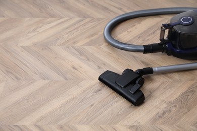 Photo of Modern vacuum cleaner on floor. Space for text