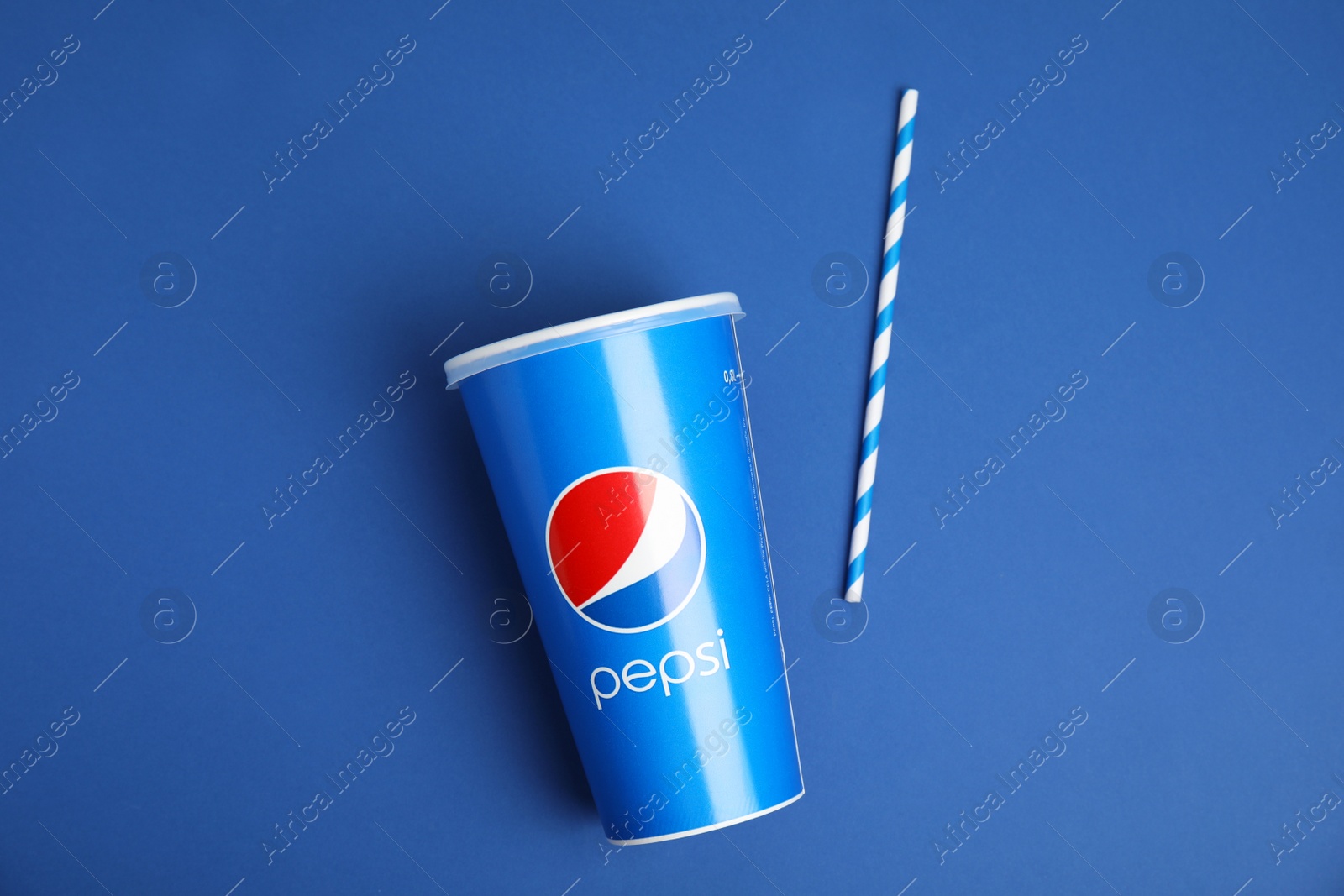 Photo of MYKOLAIV, UKRAINE - JUNE 9, 2021: Paper Pepsi cup and straw on blue background, flat lay