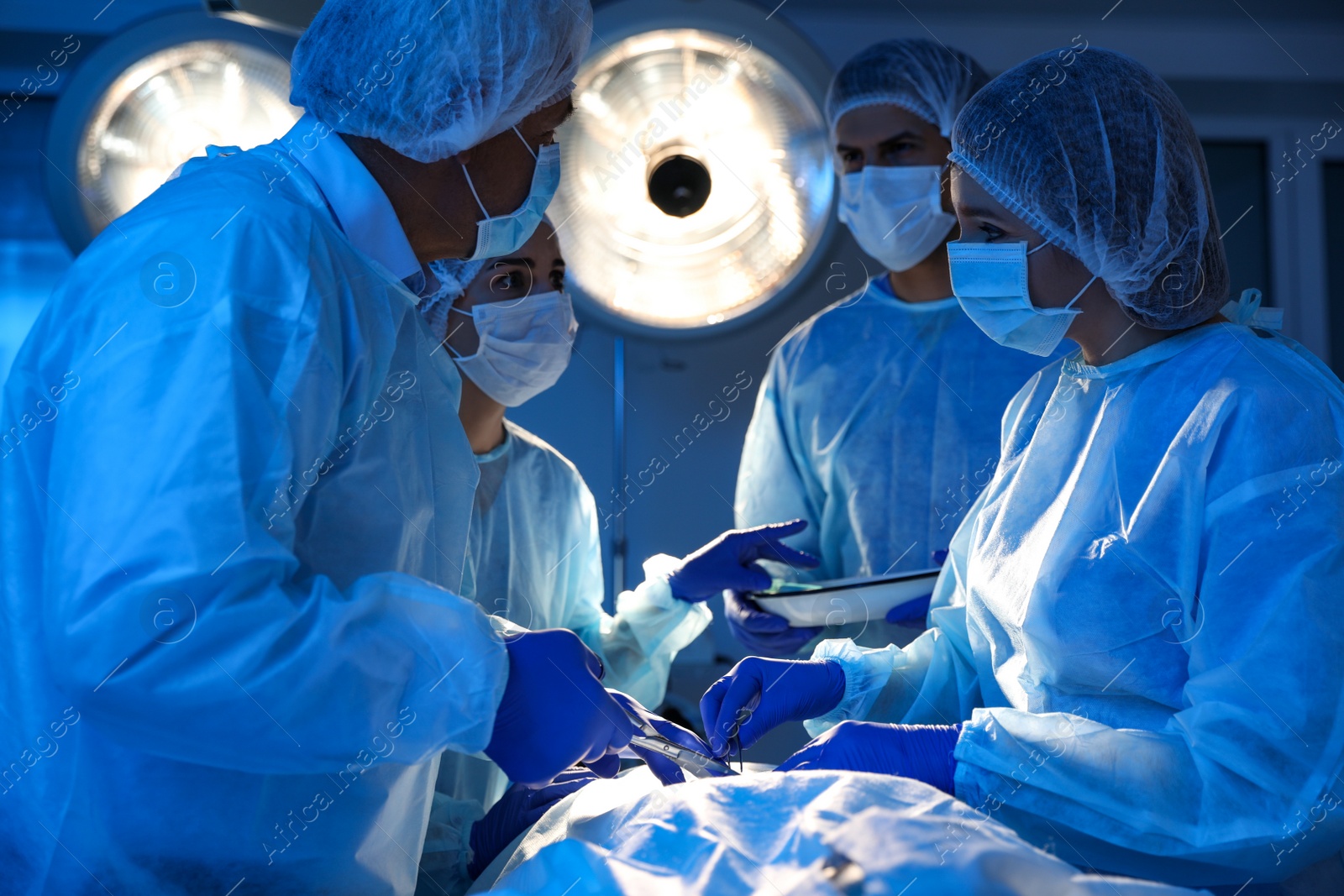 Photo of Team of professional doctors performing operation in surgery room