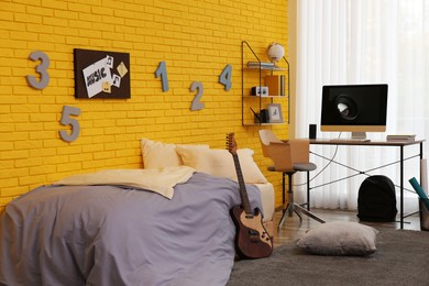 Photo of Stylish teenager's room interior with computer and bed