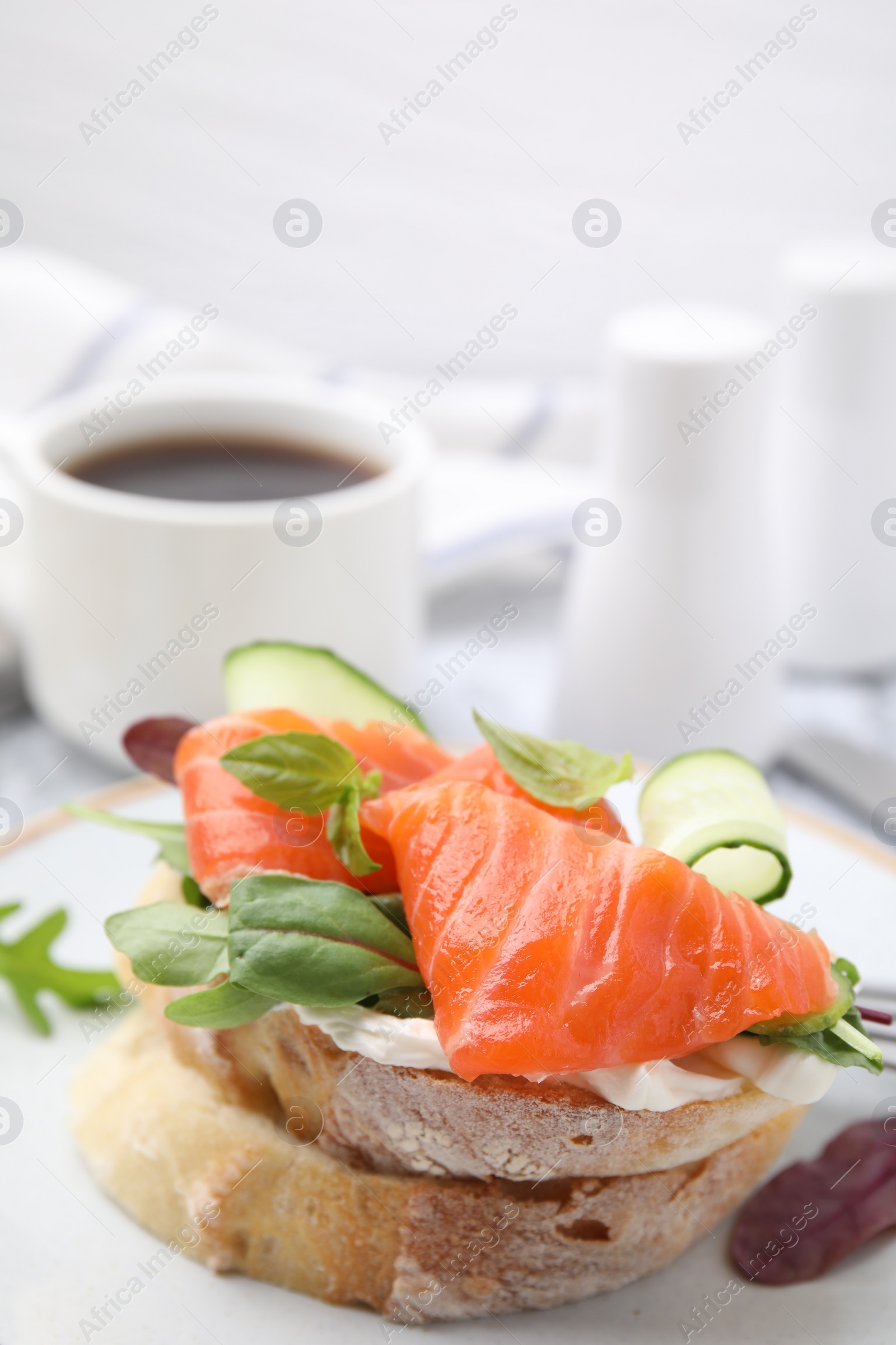 Photo of Tasty bruschetta with salmon, cucumber and herbs on plate, closeup