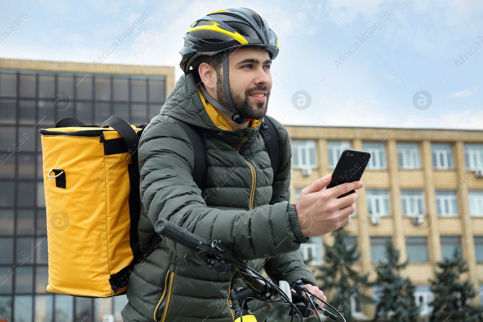 Photo of Courier with thermo bag and mobile phone on city street. Food delivery service