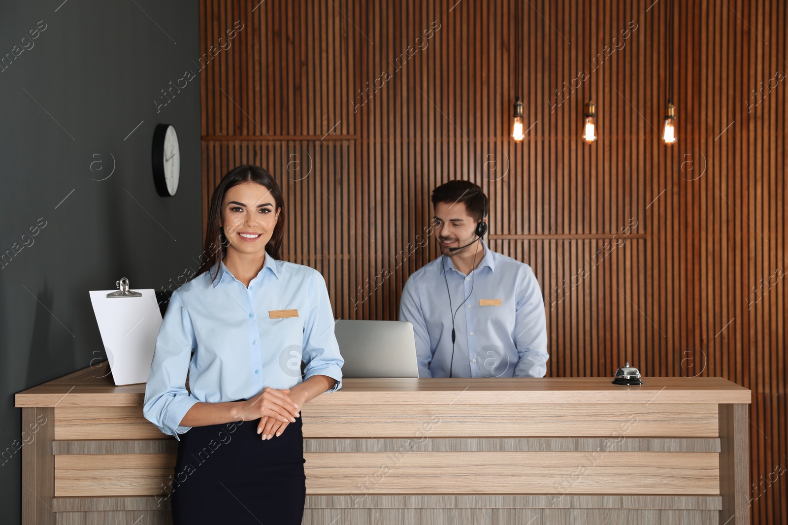 Photo of Receptionist at desk with colleague in lobby