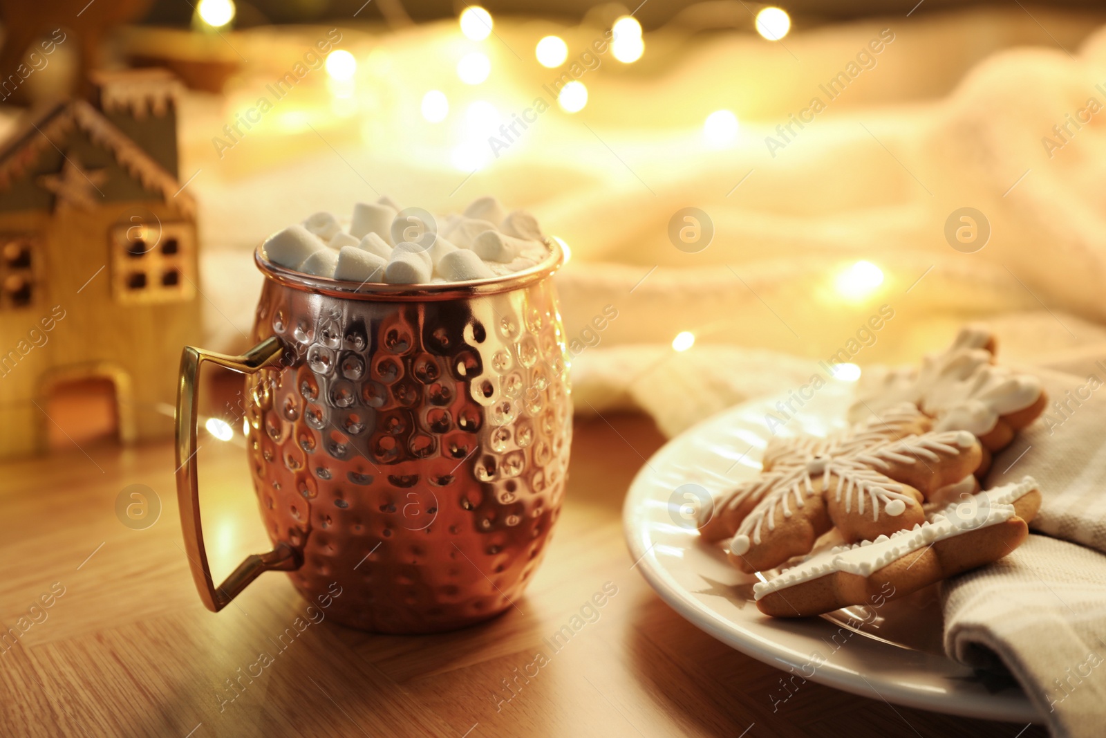 Photo of Cup of hot drink with marshmallows, cookies and Christmas decor on wooden table