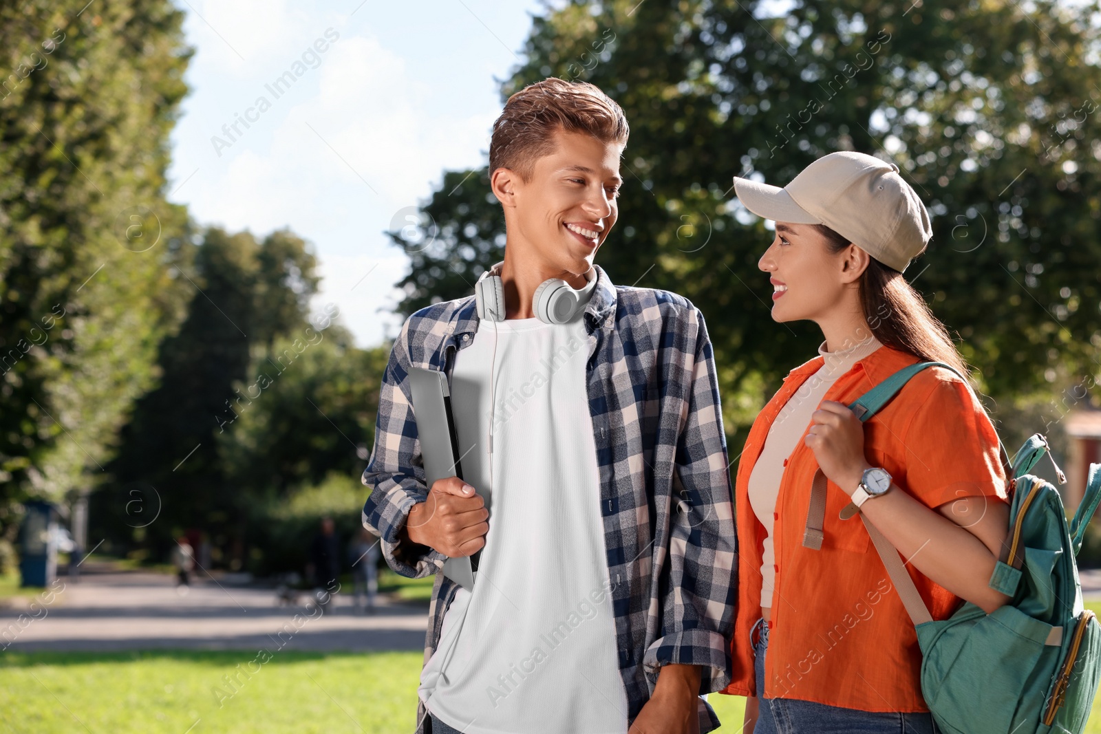 Photo of Happy young students spending time together in park