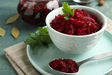 Bowl with delicious pickled beets on blue wooden table, closeup