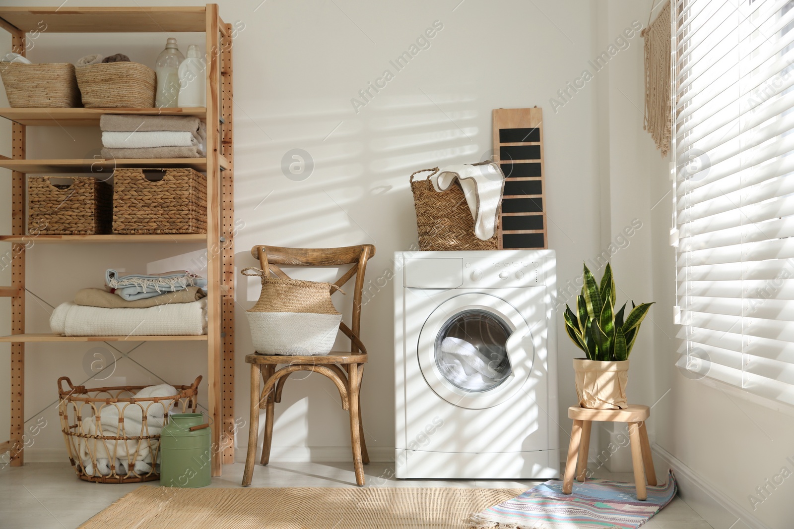 Photo of Modern washing machine in laundry room interior