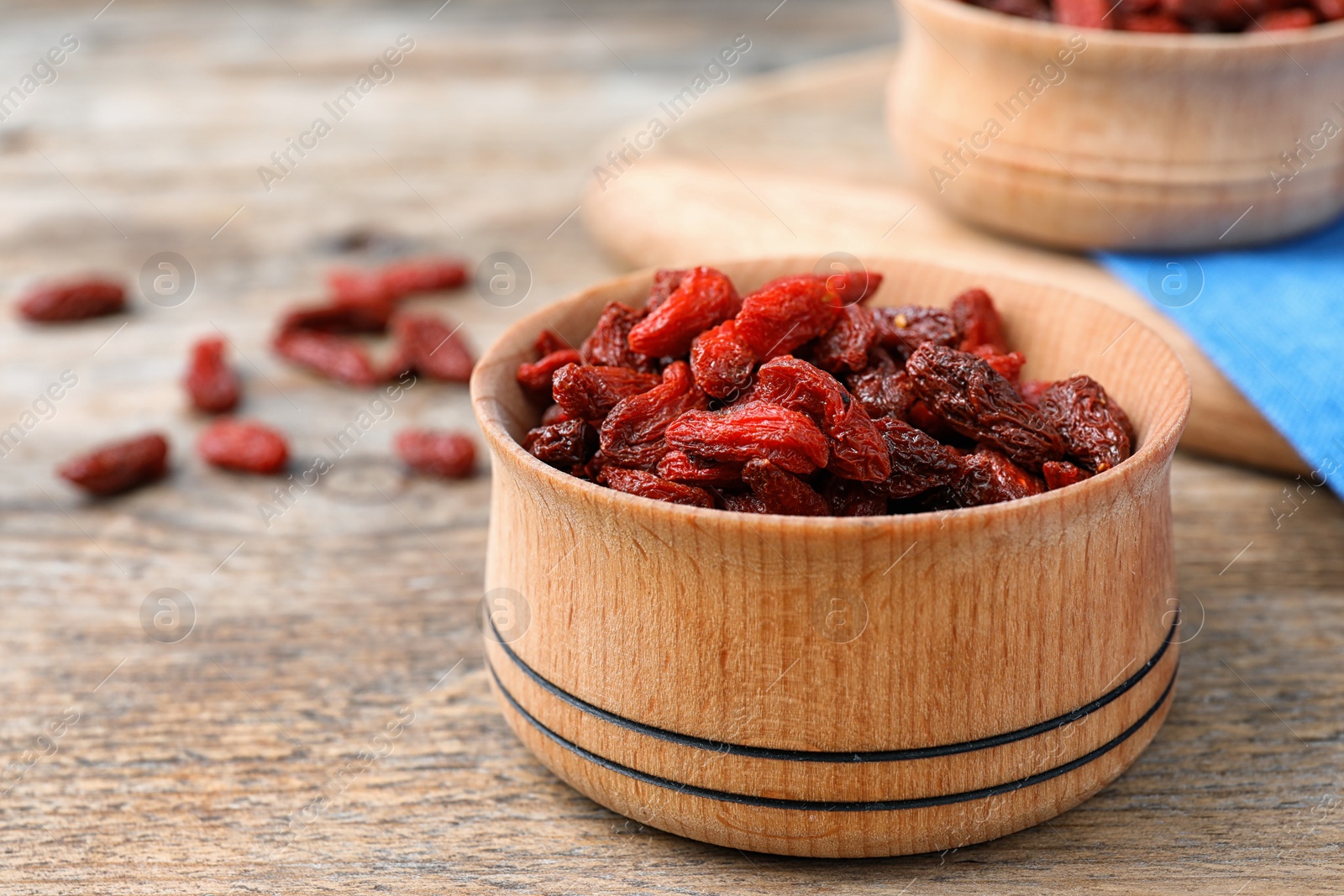 Photo of Dried goji berries in bowl on wooden table