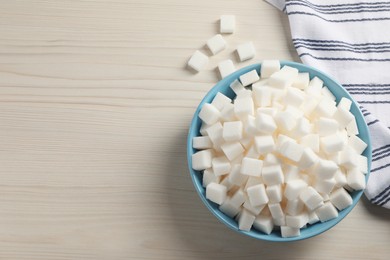 White sugar cubes on wooden table, flat lay. Space for text