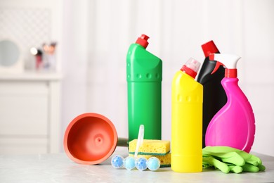 Different toilet cleaning supplies and tools on light grey table indoors, space for text