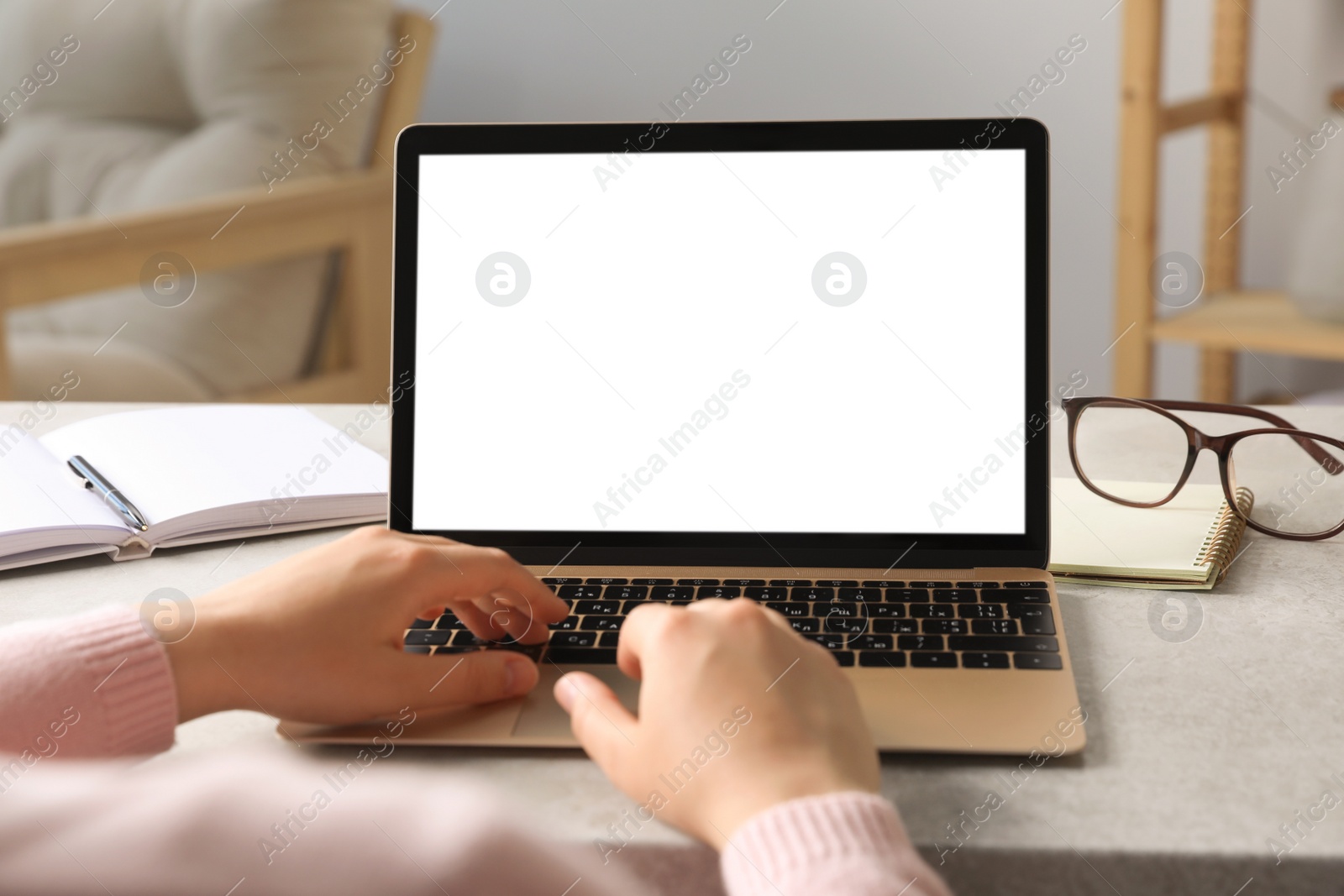 Photo of Woman working on laptop at white table, closeup. Mockup for design