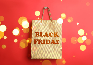 Image of Shopping bag with text BLACK FRIDAY on red background. Bokeh effect
