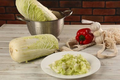 Photo of Fresh Chinese cabbage, bell pepper and garlic on wooden table