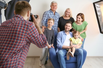 Professional photographer taking photo of family in studio