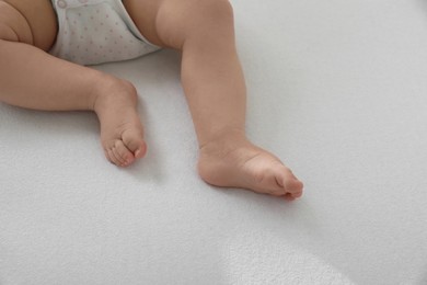 Photo of Little baby lying on bed, closeup. Space for text