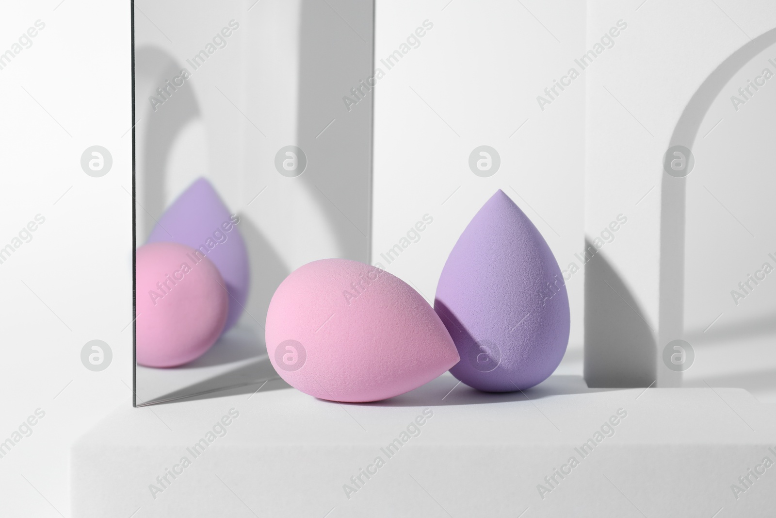 Photo of Stylish presentation of makeup sponges on white background